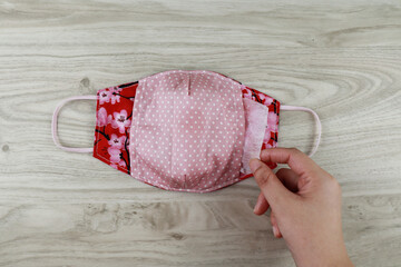 Handmade project DIY face mask made out of red cotton fabirc. A washable fabric mask as mouth cover for extra protection with filter pocket.