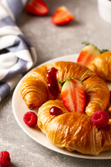 Tasty buttery croissants and berries on table.Breakfast