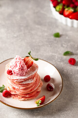 Stack of pink pancakes with strawberry. Pink colourful pancakes with berries. Breakfast