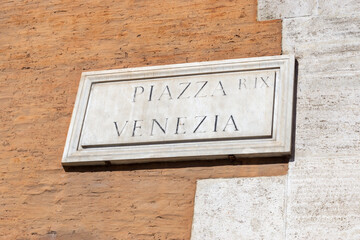Ancient Piazza Venezia sign on brick wall, Rome, Italy.