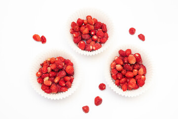 Wild strawberry served in decorative paper baskets isolated on white background.