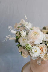Beautiful bouquet of flowers in a box. A bouquet in peach tones. Stylish bouquet of peonies, ranunculis and roses. Flower shop concept. Floristics