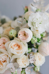 Beautiful bouquet of flowers in a box. A bouquet in peach tones. Stylish bouquet of peonies, ranunculis and roses. Flower shop concept. Floristics