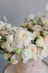 Beautiful bouquet of flowers in a box. A bouquet in peach tones. Stylish bouquet of peonies, ranunculis and roses. Flower shop concept. Floristics