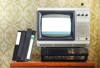 Old silver-colored TV with a VCR on the background of wallpaper.Screen noise.