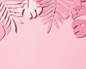 Toned photo of hand cut paper tropical plants leaves on the pink background. Summer concept Top view
