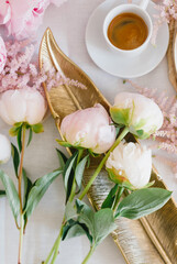 A cup of coffee, berry tartlet with fresh berries and peonies. Flat lay, composition. Coffee, dessert and flowers. Concept of coffee shop, cafe and flower shop.
