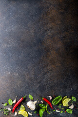 Assortment of spices, herbs and greens. Ingredients for cooking. Food background. Black stone table, Copy space for text. Top view.