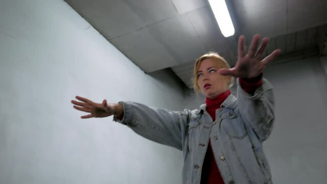 zombie girl walks along the dim corridor of an office building with gray walls