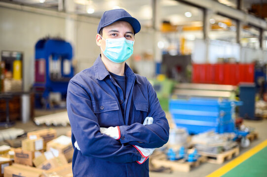Portrait of a worker in an industrial plant wearing a mask, coronavirus concept