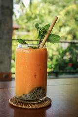 Mango smoothie in glass with bamboo drinking straws