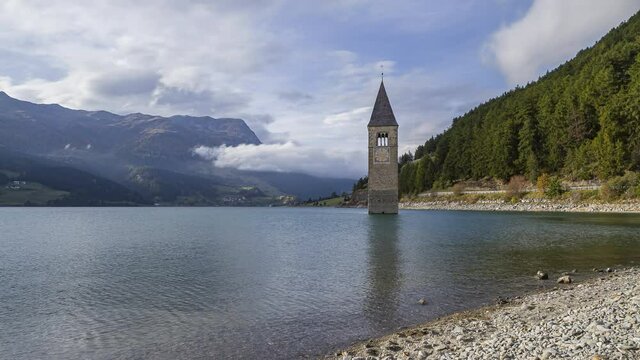 Reschenpass, Italy - October 12, 2014: Reschen lake is a reservoir in South Tirol.   The bell tower of the flooded village of Graun looks out of the water.