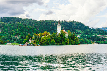 Ancient church in the middle of the lake surrounded by colourful trees