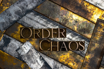 Photo of real authentic typeset letters forming Order Chaos text on vintage textured silver grunge...
