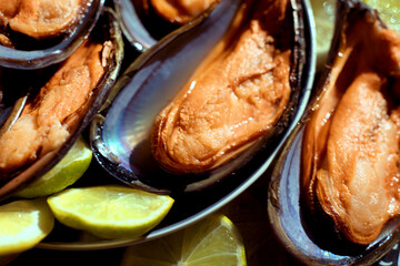 Boiled mussels with lemon close-up.