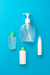 Hand sanitizer, alcohol spray, soap and cleaning products for disinfection and cleaning on blue background