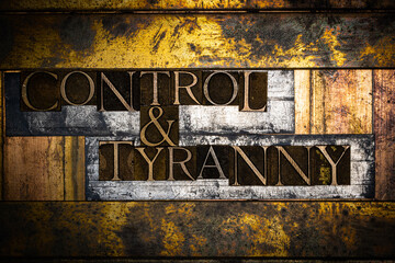 Photo of real authentic typeset letters forming Control and Tyranny text on vintage textured silver grunge copper and gold background
