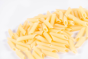 Raw penne pasta on a white background