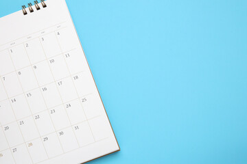calendar page close up on blue background business planning appointment meeting concept