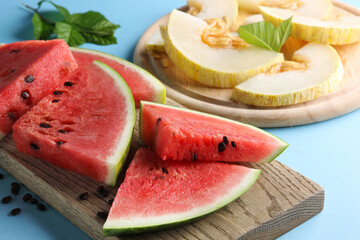 Berries and fruit. Watermelon and melon pieces  on a wooden board on a bright blue background.  Background image, copy space
