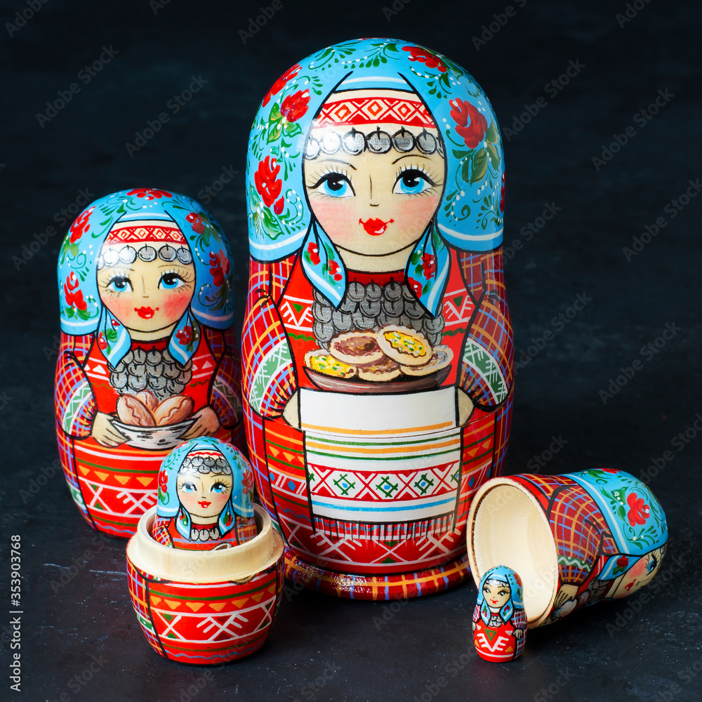 Wall mural Five red matryoshka. Traditional Russian toy. Black concrete background.