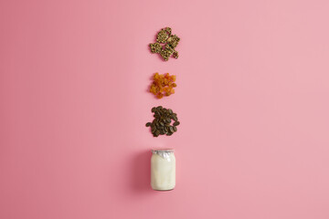 Ingredients for preparing nourishing quick snack. Yoghurt, dried fruits and pumpkin seeds to make organic delicious dessert. Natural healthy nutrition concept. Breakfast time. Making tasty meal