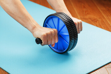 Sports blue roll for training the abs in the hands.