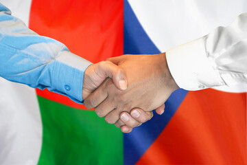 Handshake on Madagascar and Czech Republic flag background. Support concept.