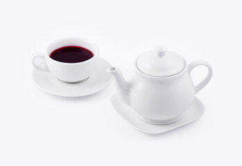 white tea cup with red tea and white teapot on white background