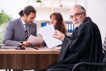 Young woman in courthouse with judge and lawyer