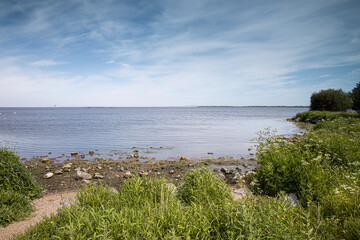 Fototapeta na wymiar View of Lough Neagh on a warm sunny spring day in May with green foliage in the foreground