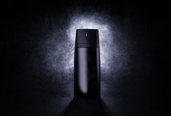 Deodorant in a black metal can on a black background with splashes at the back. Advertising photo...