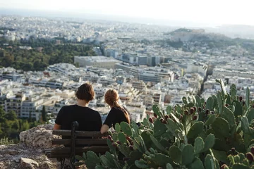 Schilderijen op glas Couple of young people looking at Athens, Athens, Greece © Kseniia