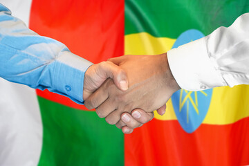 Handshake on Madagascar and Ethiopia flag background. Support concept.