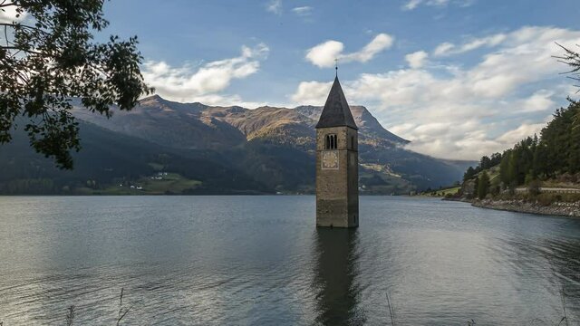 Reschenpass, Italy - October 12, 2014: Reschen lake is a reservoir in South Tirol.   The bell tower of the flooded village of Graun looks out of the water.