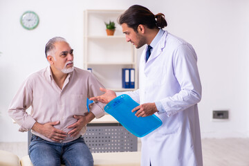 Fototapeta premium Old patient visiting young male doctor