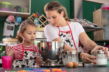 Una mamma prepara dei dolci in cucina insieme alla figlia