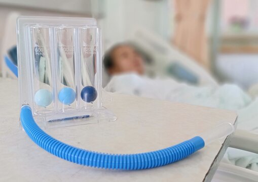 Triflow incentive spirometer for patients.Triflow or Tri-ball on table.Selective focus with Female patients lie on the bed.Blur background.