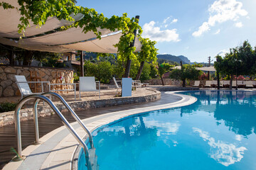 backyard of a hotel with a swimming pool and great mountain view. Pool ladder.
