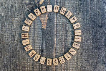 Scandinavian wooden runes on an old wooden table. Elder Futhark.