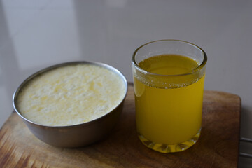 glass of ghee with bowl of curd