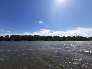 Lake with waves against the background of an ancient park
