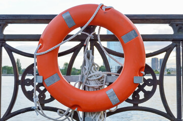 lifebuoy on the city embankment, a symbol of saving lives, help and support for business