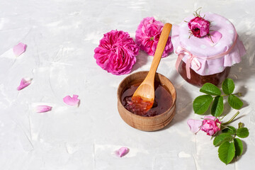 Fototapeta na wymiar Homemade tea rose petal jam on a light table with copy space