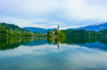 Beautiful morning at Lake Bled and Julian Alps in the background. The lake island and charming...