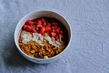 Healthy Vegan Homemade Breakfast. Oatmeal with strawberry sauce, coconut and granola.