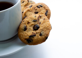 White cup of tea with cookies with chocolate chips on a white background