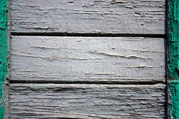 The natural surface of painted wood on wall houme. The surface of the old wooden cladding wall of the house. Cracked paint closes the texture of wooden boards. Old paint on the wall of the house. 