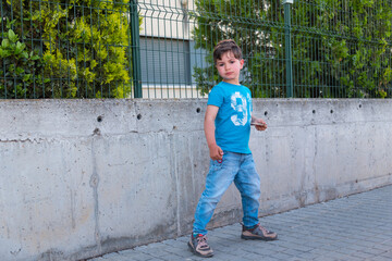 5-year-old boy looking left with blue t-shirt and jeans