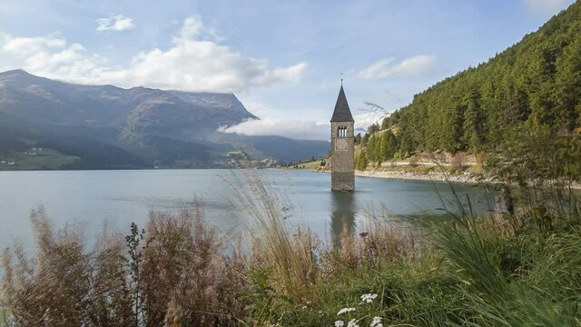 Reschenpass, Italy - October 12, 2014: Reschen lake is a reservoir in South Tirol.   The bell tower of the flooded village of Graun looks out of the water.